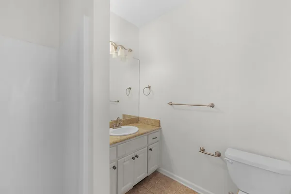 a bathroom with a granite countertop sink toilet and vanity