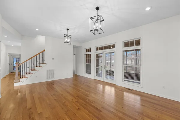 a view of empty room with wooden floor and windows