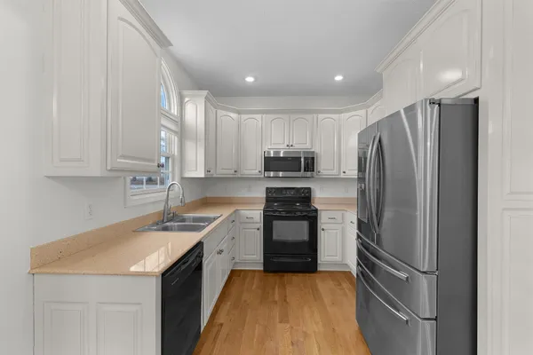 a kitchen with stainless steel appliances granite countertop a refrigerator sink and stove