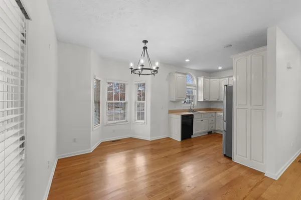 a kitchen with kitchen island stainless steel appliances refrigerator dining table and chairs