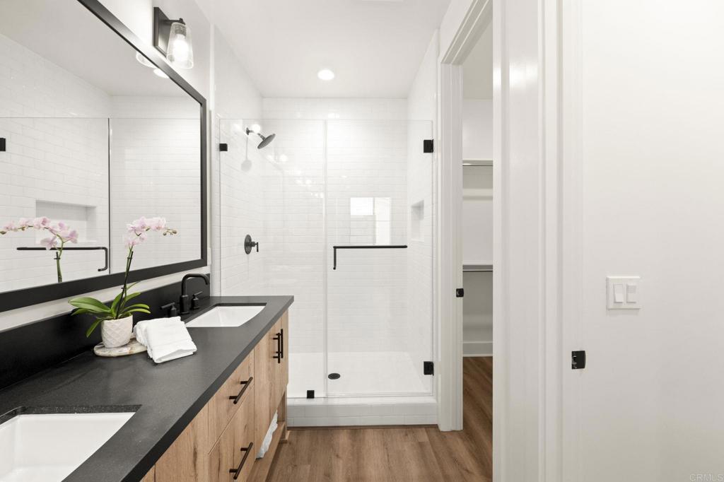 1303 Bergamo, Unit 201 Encinitas, CA 92024 - Photo 13 of 42 a bathroom with a granite countertop sink a toilet a mirror and shower