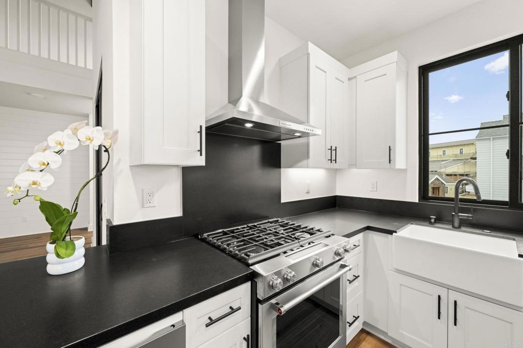 1303 Bergamo, Unit 201 Encinitas, CA 92024 - Photo 7 of 42 a view of kitchen island a sink stainless steel appliances and cabinets