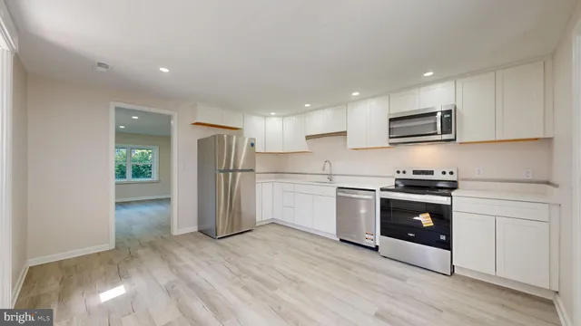 a kitchen with stainless steel appliances granite countertop a refrigerator and a stove top oven