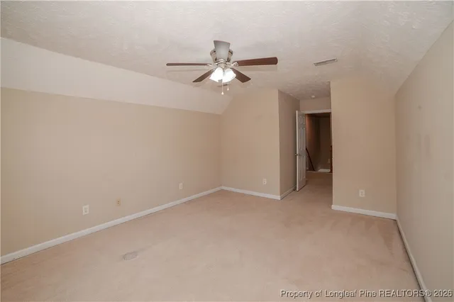 an empty room with closet and a ceiling fan