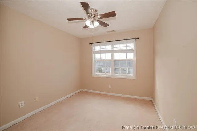 an empty room with a window and a ceiling fan