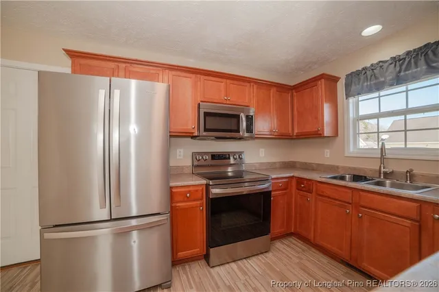 a kitchen with stainless steel appliances granite countertop a refrigerator sink and microwave