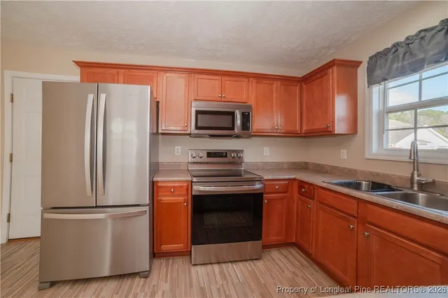 a kitchen with a refrigerator sink and wooden floor