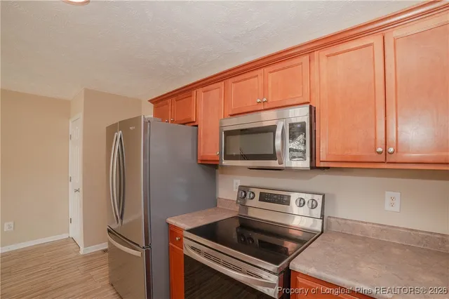 a kitchen with stainless steel appliances a microwave a sink and cabinets
