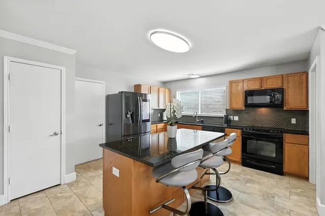 a kitchen with stainless steel appliances granite countertop a sink a stove and refrigerator
