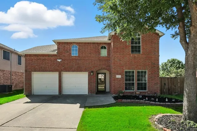 a front view of a house with a garden and yard