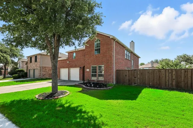 a front view of a house with a yard and trees