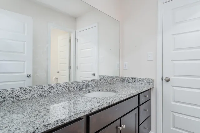 a bathroom with a granite countertop sink and a mirror
