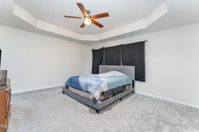 a bedroom with a bed and a ceiling fan