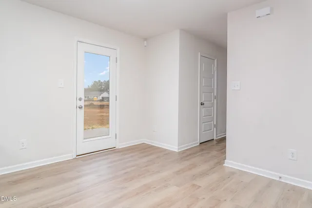 an empty room with wooden floor and a window