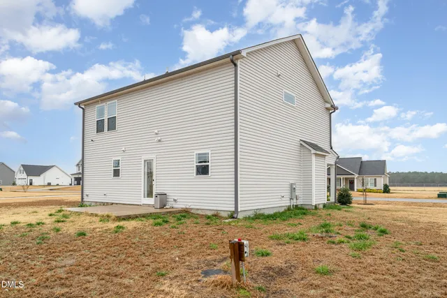 a view of a house with backyard and trees