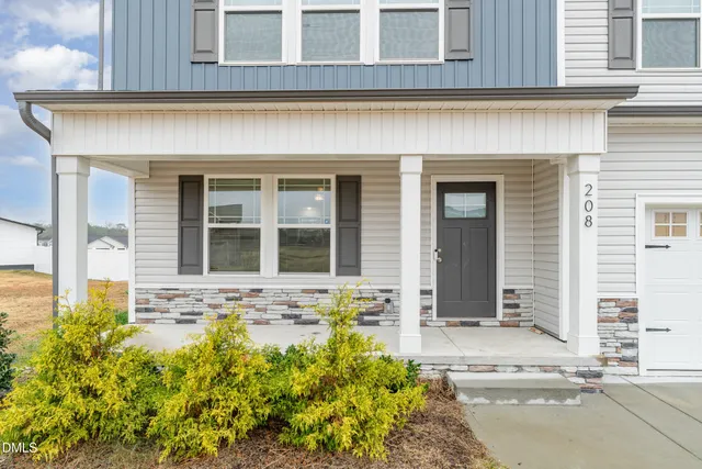 front view of a brick house with potted plants