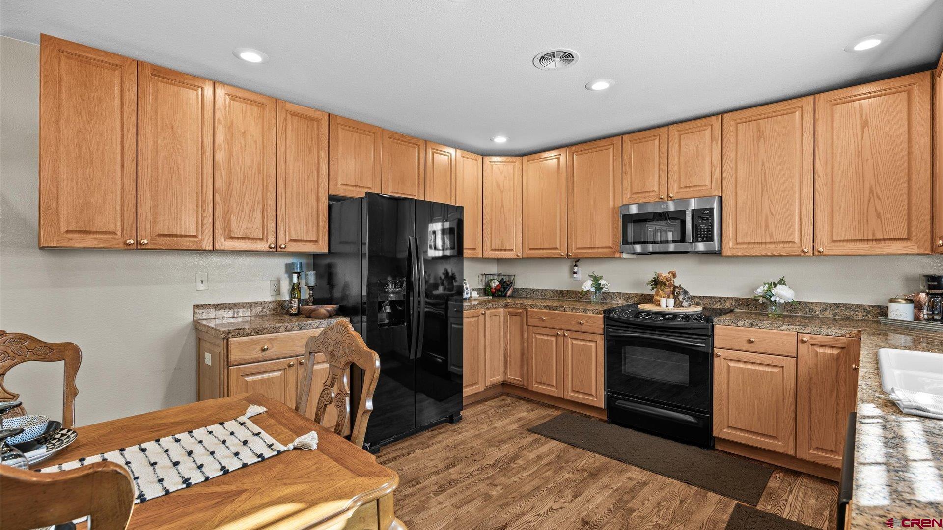 522 Leon Street Delta, CO 81416 - Photo 18 of 31 a kitchen with stainless steel appliances granite countertop a stove top oven a sink dishwasher and a refrigerator with wooden floor