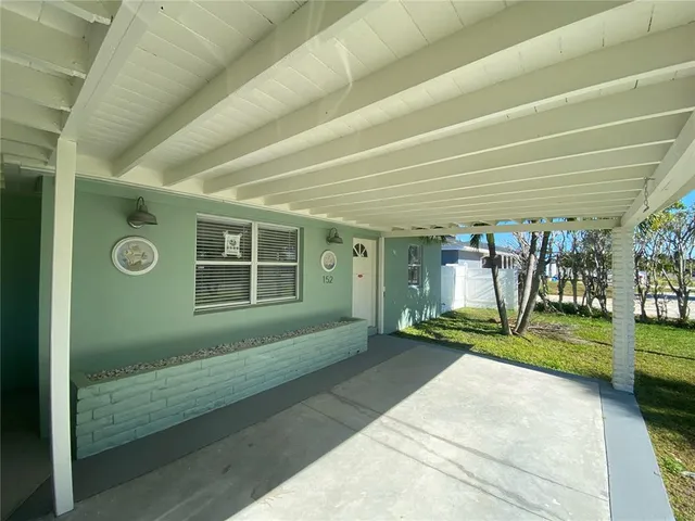a view of a house with porch and garden