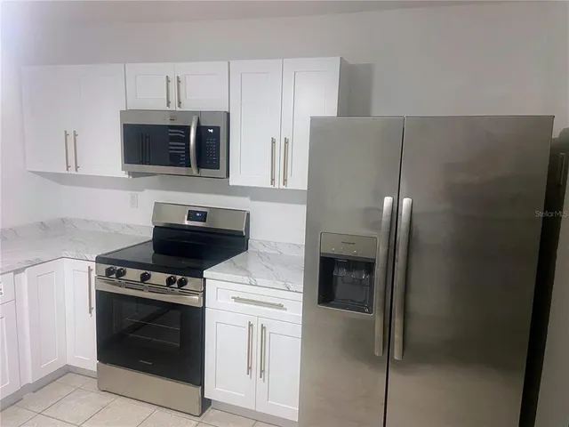 a kitchen with cabinets and steel stainless steel appliances
