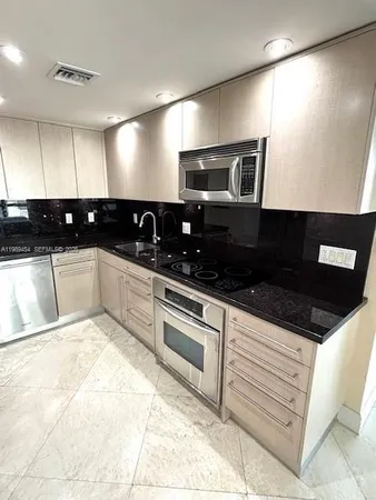 a kitchen with stainless steel appliances a sink and cabinets
