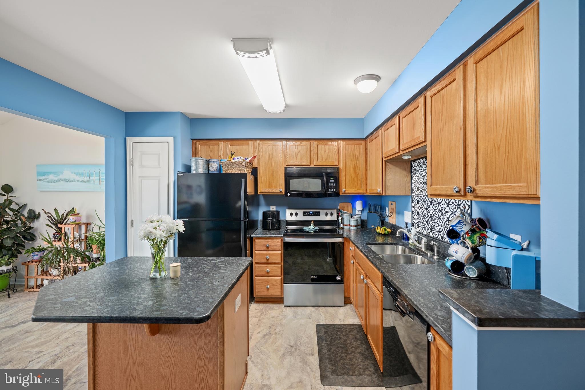 27548 Mayfield Road, Unit 42 Millsboro, DE 19966 - Photo 9 of 46 a kitchen with stainless steel appliances granite countertop sink stove top oven and cabinets