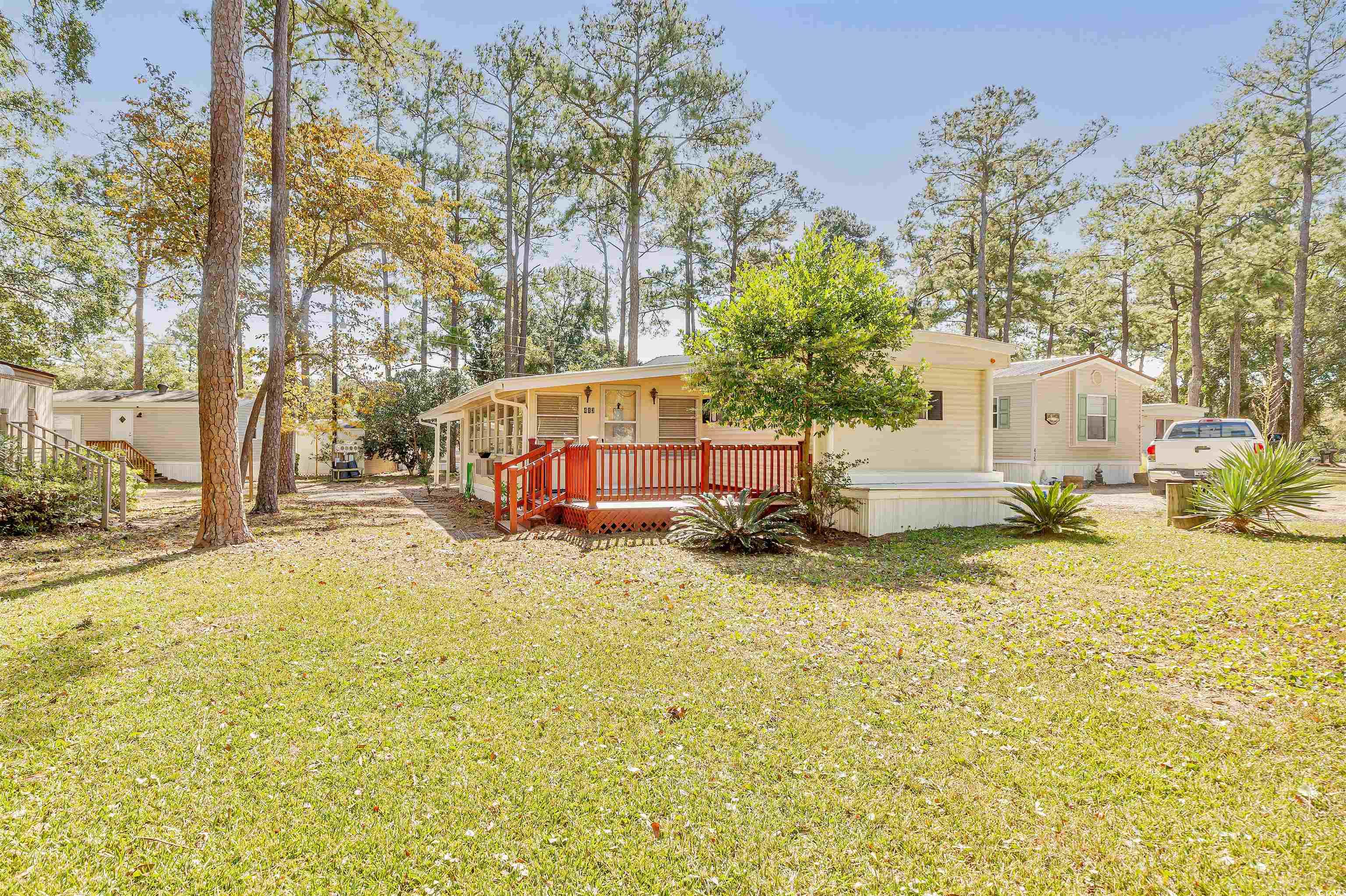 Back of property with a deck and a lawn