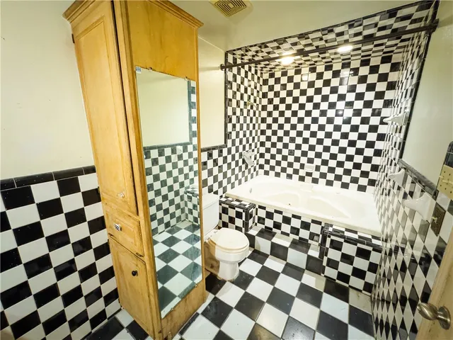 a bathroom with a black and white checkered floor