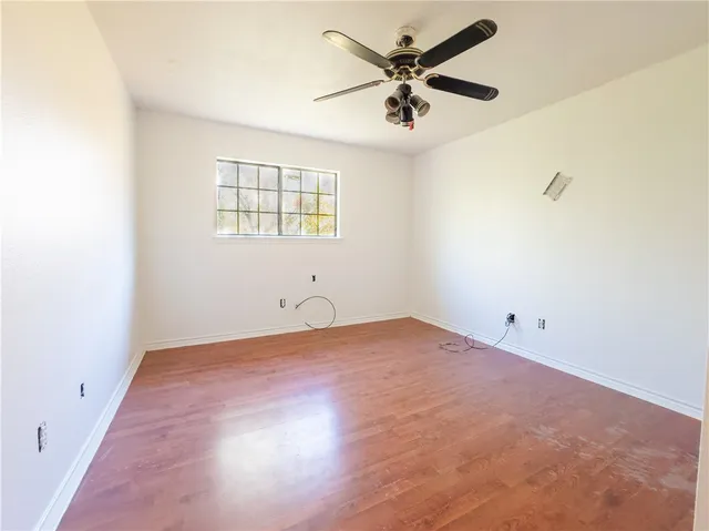 an empty room with a window and a fan