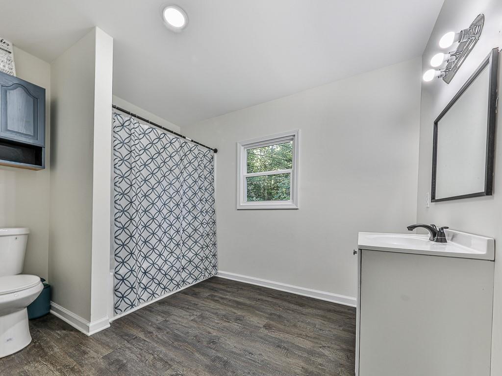 87 Jones Street Jasper, GA 30143 - Photo 14 of 25 a bathroom with a sink a toilet and shower curtain