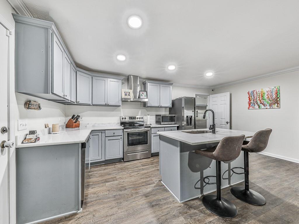 87 Jones Street Jasper, GA 30143 - Photo 2 of 25 a kitchen with stainless steel appliances granite countertop a sink a stove a refrigerator cabinets and a dining table with wooden floor