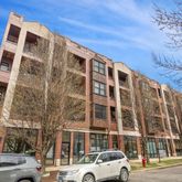 a front view of a building with lot of cars and trees