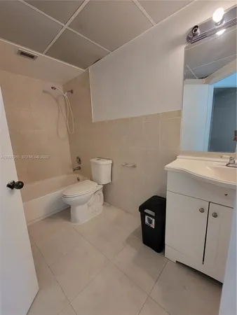 a white toilet sitting next to a bath tub