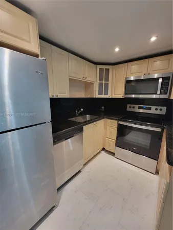 a kitchen with granite countertop a refrigerator and a stove top oven