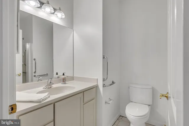 a bathroom with a granite countertop sink a toilet and a mirror