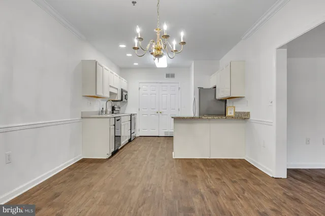 a kitchen with kitchen island white cabinets and stainless steel appliances