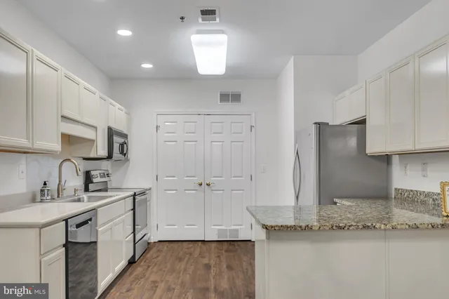 a kitchen with granite countertop a sink and cabinets
