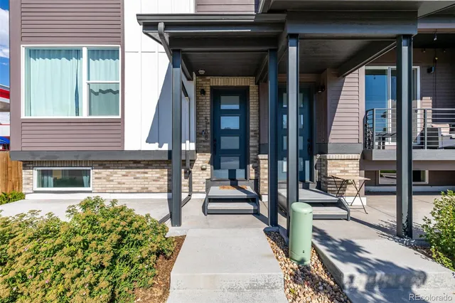 a view of a patio with table and chairs and floor to ceiling window