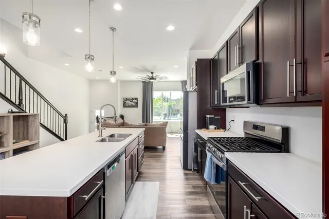 a kitchen with stainless steel appliances a sink a stove cabinets a refrigerator and a stove