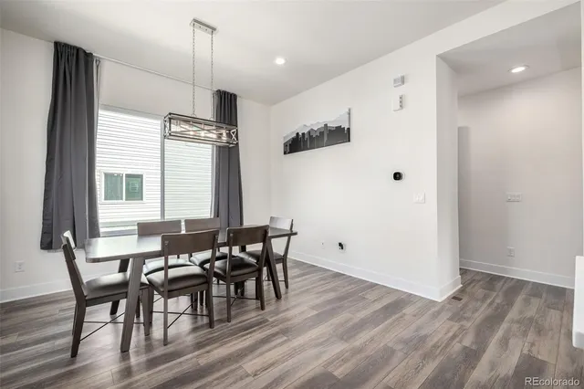 a view of a a dining room with furniture window and wooden floor