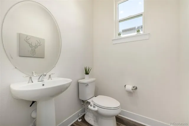 a bathroom with a sink toilet and mirror