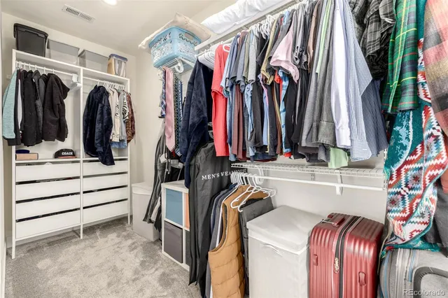 a view of walk in closet with clothes and shoes