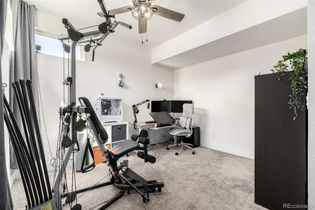 a view of a workspace with furniture and a ceiling fan