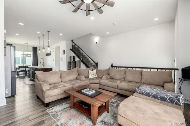 a living room with furniture and a wooden floor