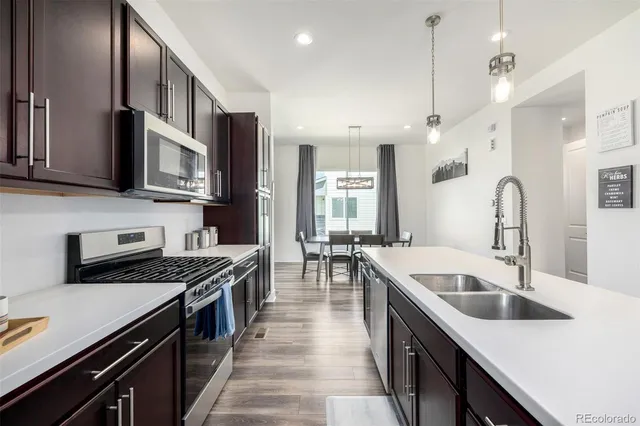 a kitchen with stainless steel appliances granite countertop a sink stove and cabinets