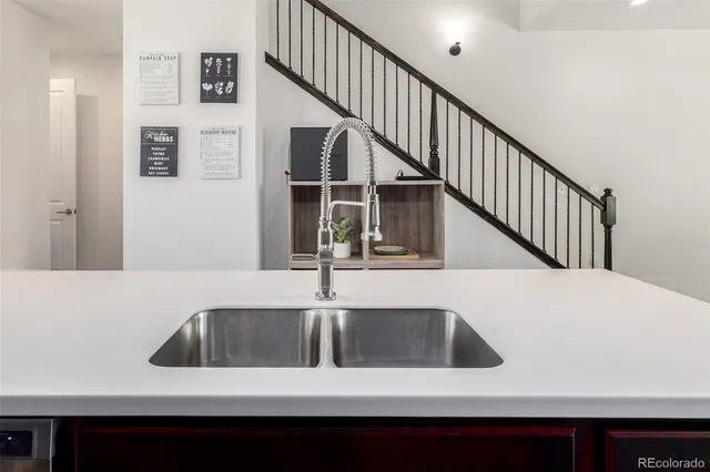 a kitchen with a sink a refrigerator and white cabinets