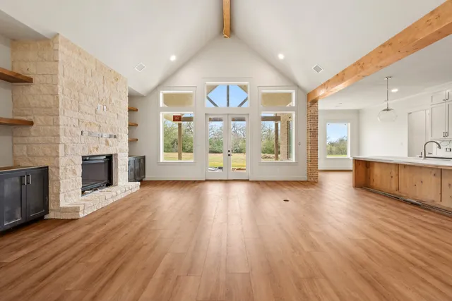 a view of a livingroom with wooden floor and a kitchen space