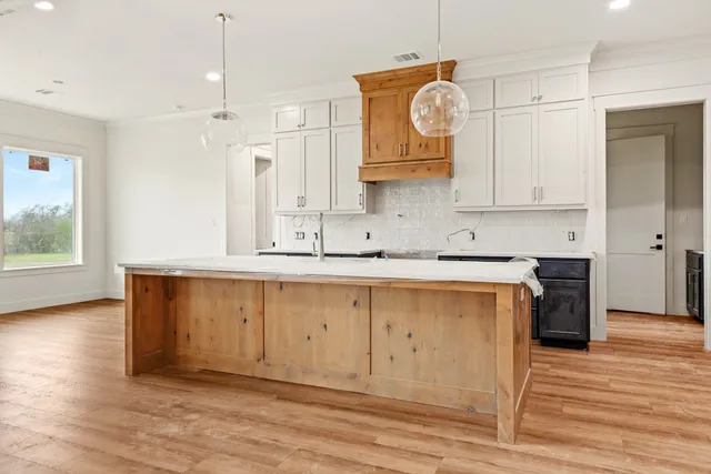 a kitchen with a sink stove and cabinets