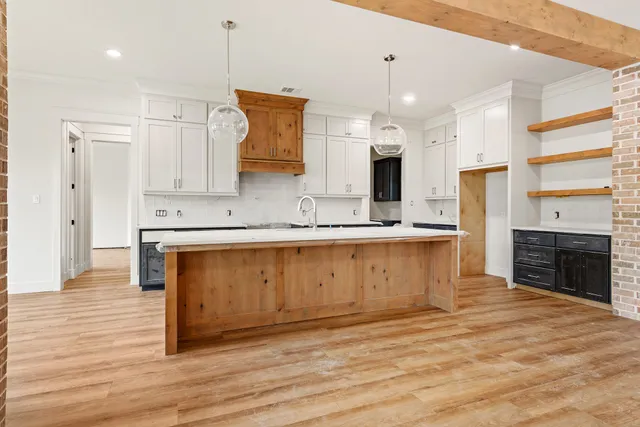 a large kitchen with stainless steel appliances granite countertop a large stove a sink dishwasher and a refrigerator with wooden floor