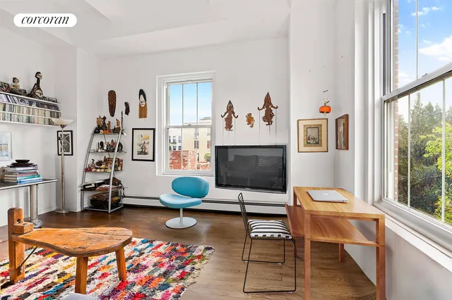 a living room with furniture a flat screen tv and a window