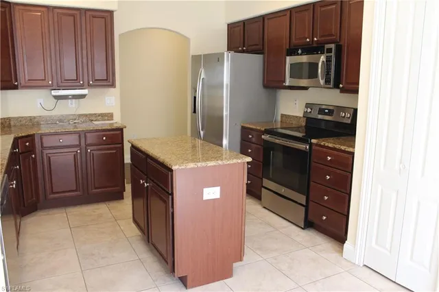 a kitchen with stainless steel appliances granite countertop a refrigerator and a stove top oven
